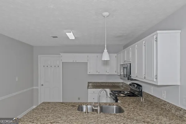 a kitchen with stainless steel appliances granite countertop a sink stove and cabinets