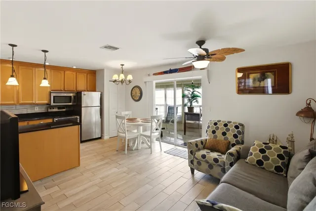 a living room with furniture dining table and a refrigerator