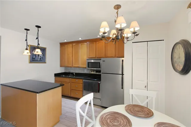 a kitchen with stainless steel appliances granite countertop a sink a stove a refrigerator and cabinets