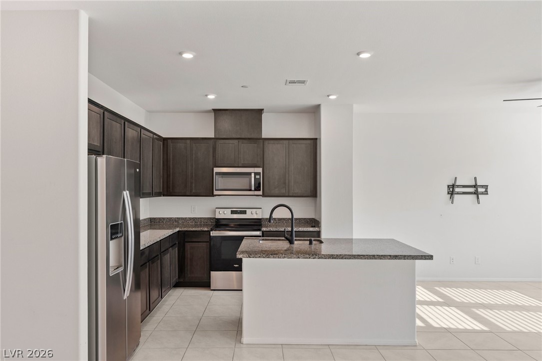 6227 Runestone Street Las Vegas, NV 89113 - Photo 21 of 33 This modern kitchen features a spacious island, sleek appliances, and ample cabinet space.