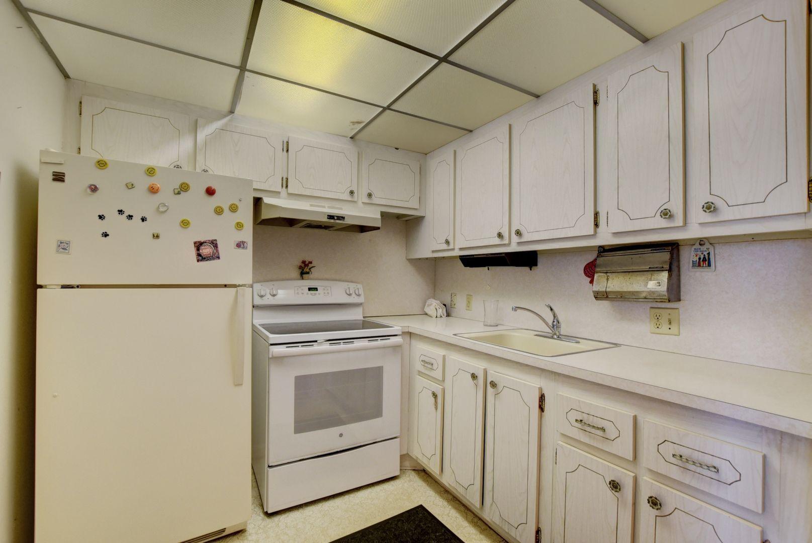 246 Suffolk F Boca Raton, FL 33434 - Photo 3 of 15 a kitchen with stainless steel appliances granite countertop a sink stove and refrigerator