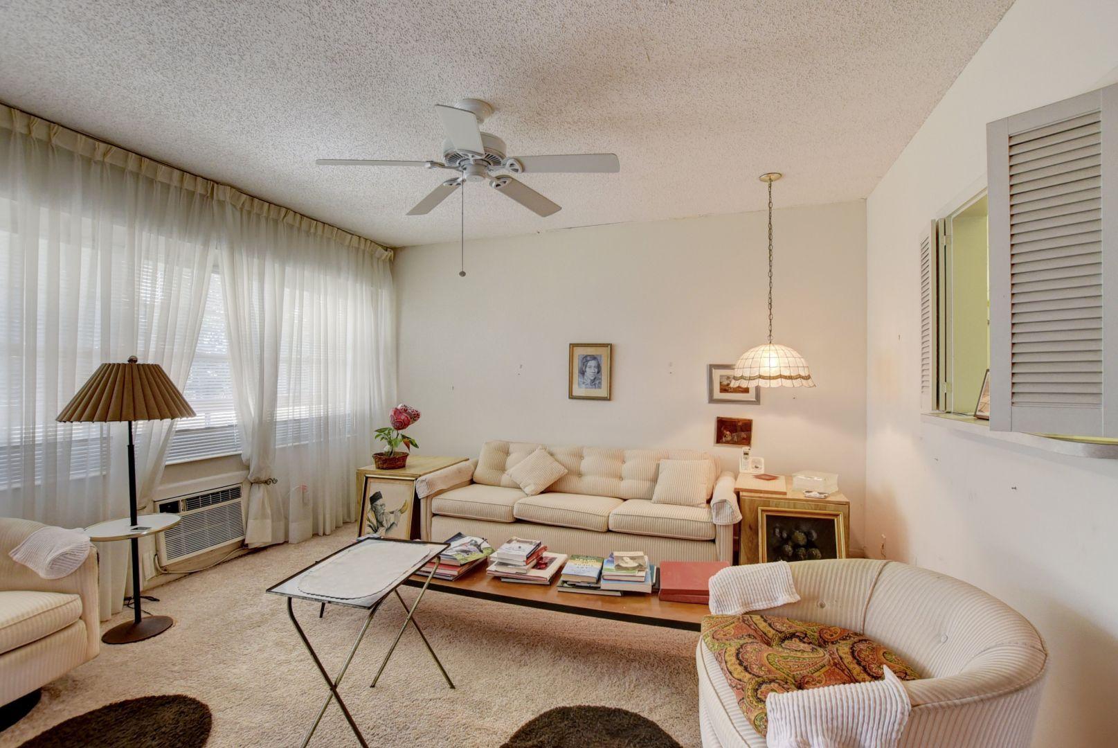 246 Suffolk F Boca Raton, FL 33434 - Photo 6 of 15 a living room with furniture and a chandelier