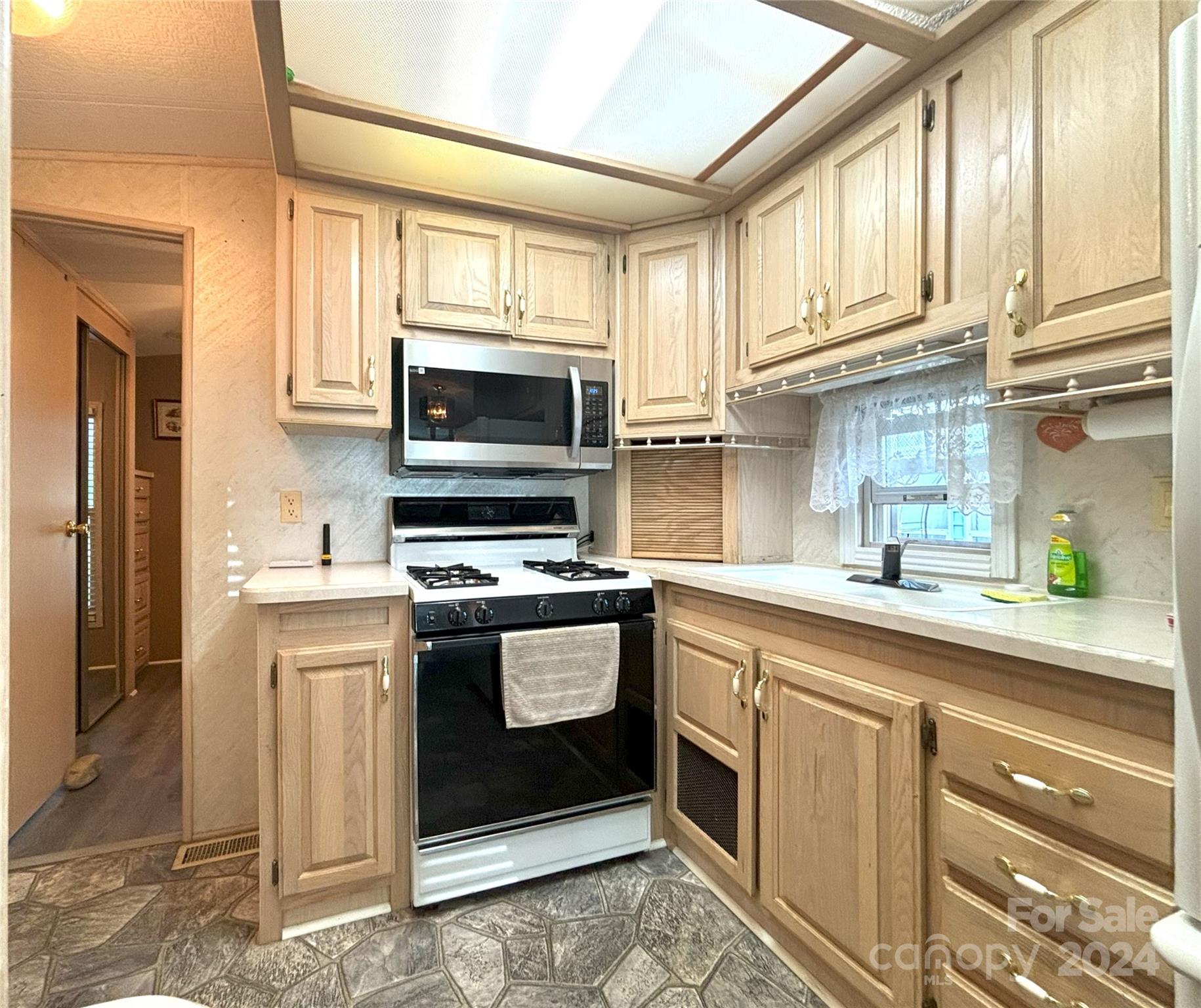 306 Mallard Loop Waynesville, NC 28785 - Photo 11 of 34 a kitchen with stainless steel appliances granite countertop a stove a sink and a microwave