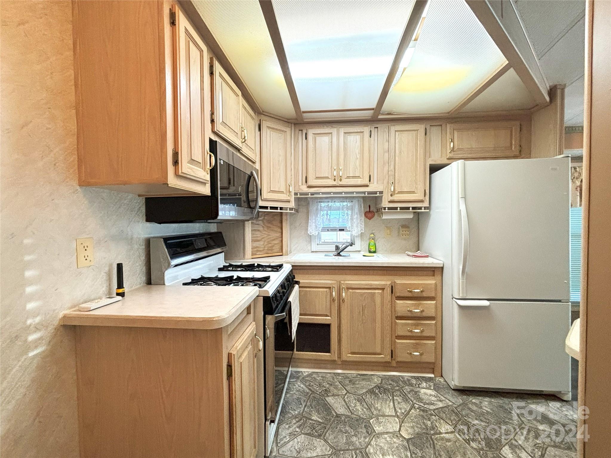 306 Mallard Loop Waynesville, NC 28785 - Photo 12 of 34 a kitchen with stainless steel appliances a refrigerator sink and microwave