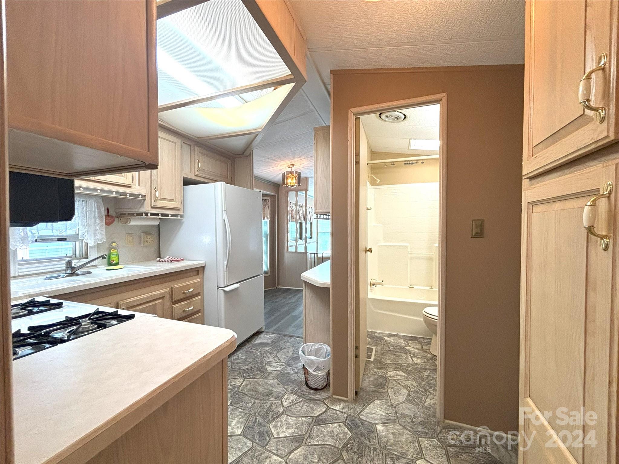 306 Mallard Loop Waynesville, NC 28785 - Photo 14 of 34 a kitchen view with a sink stove and refrigerator