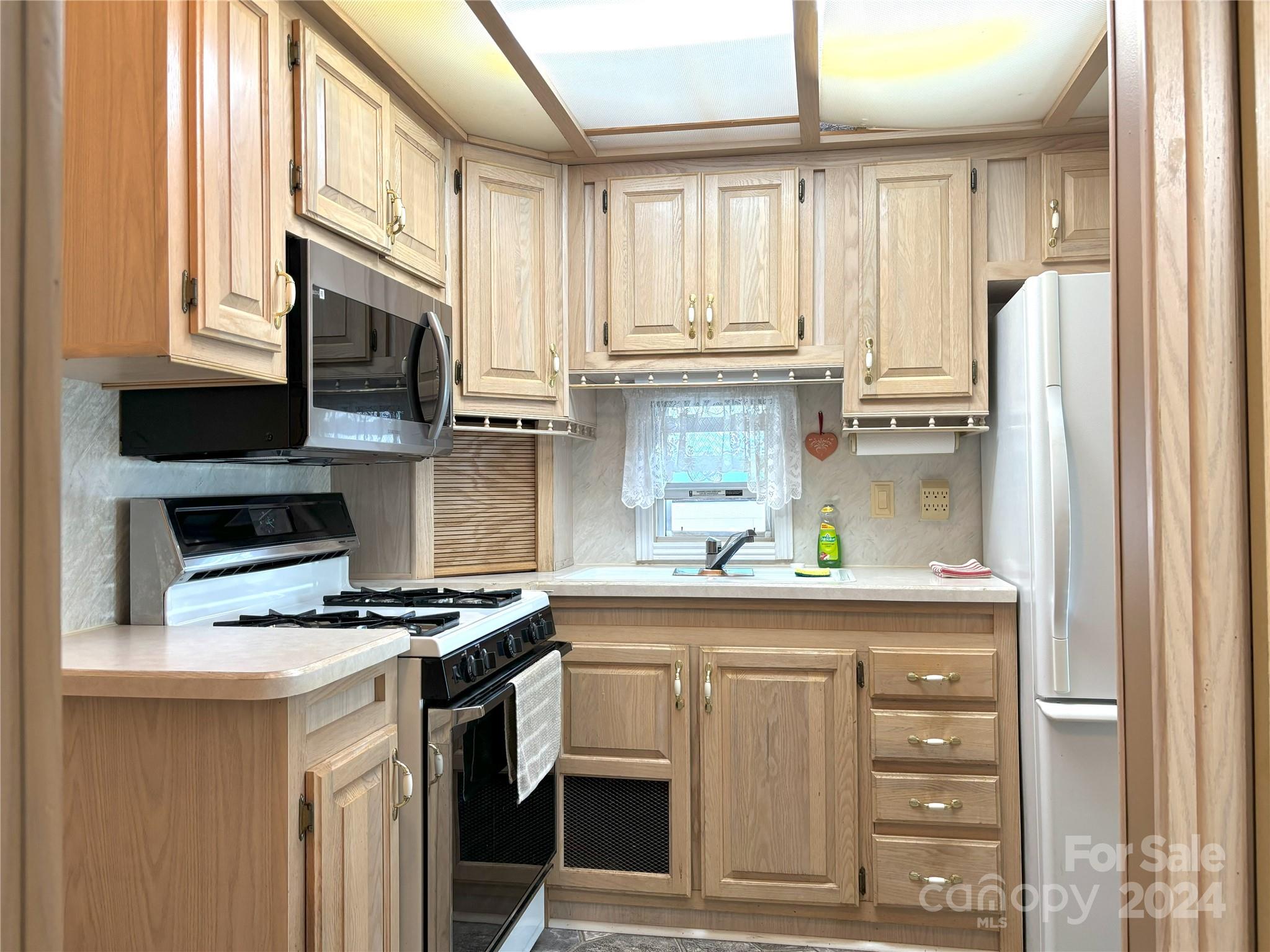 306 Mallard Loop Waynesville, NC 28785 - Photo 10 of 34 a kitchen with stainless steel appliances a stove a sink and a refrigerator