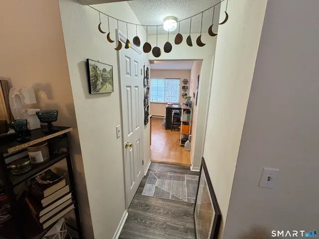a view of a hallway with wooden floor and stairs