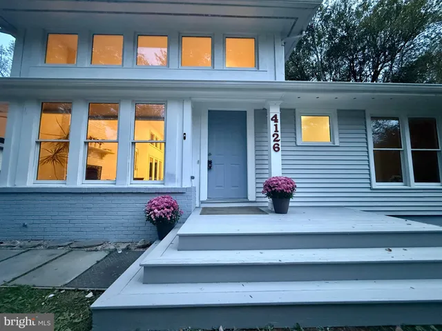 a car parked in front of a house with a garden