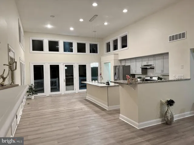 a large kitchen with stainless steel appliances granite countertop a stove a sink and a microwave