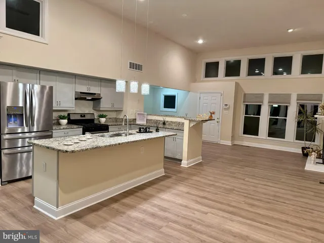 a kitchen with stainless steel appliances kitchen island wooden cabinets and fireplace