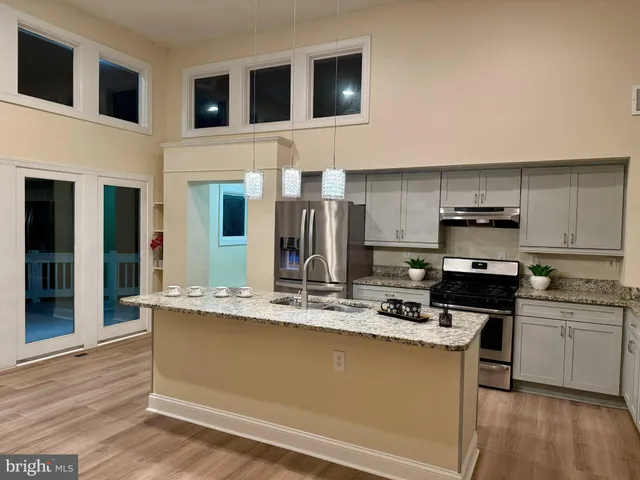 a kitchen with stainless steel appliances granite countertop a refrigerator and a sink