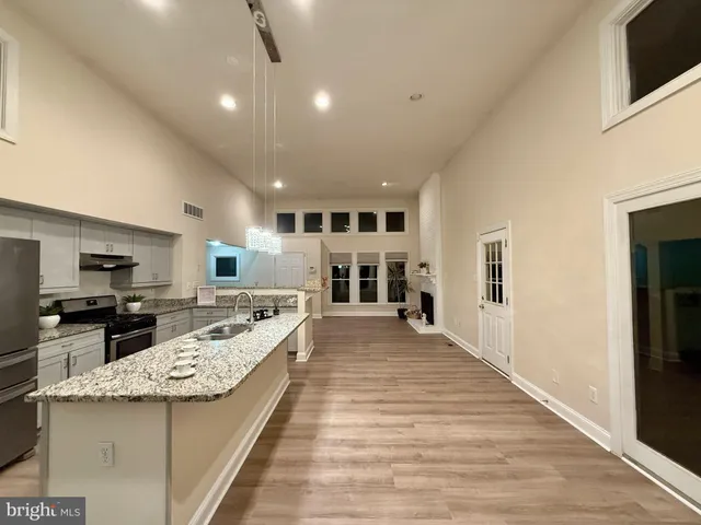 a kitchen with granite countertop a sink stainless steel appliances and cabinets