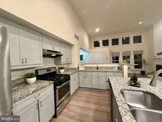 a kitchen with stainless steel appliances granite countertop a stove and a sink