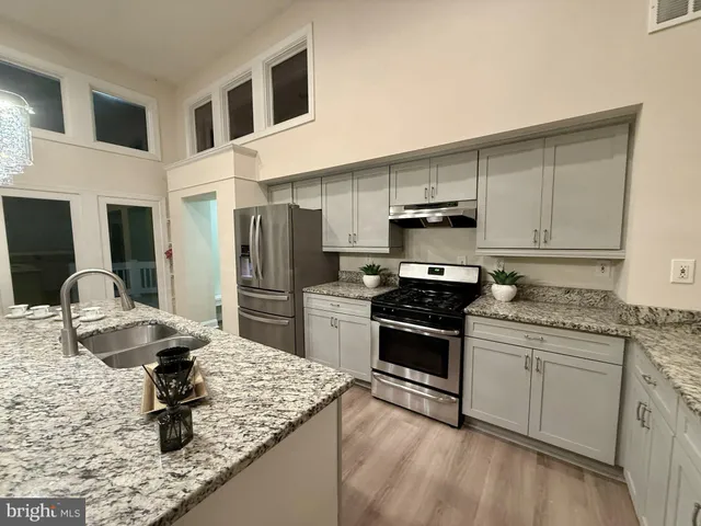 a view of a hallway to an empty room with wooden floor and a cabinet
