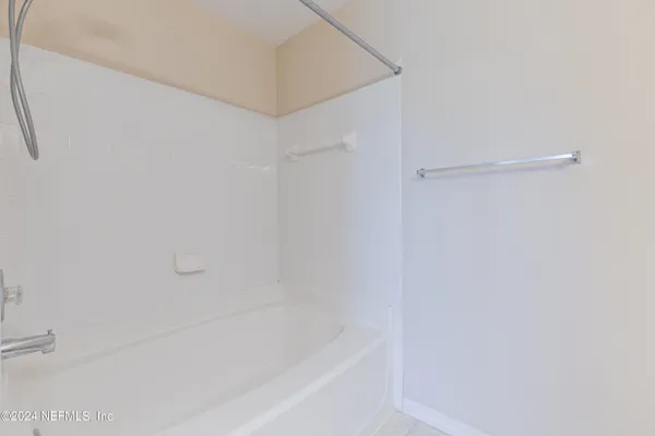 an empty room with a chandelier fan and windows