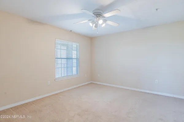 a view of an empty room with a chandelier fan