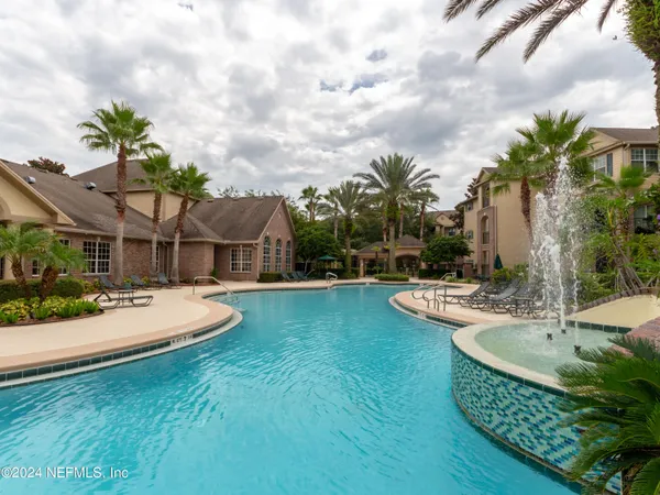 a view of a house with a big yard and large trees