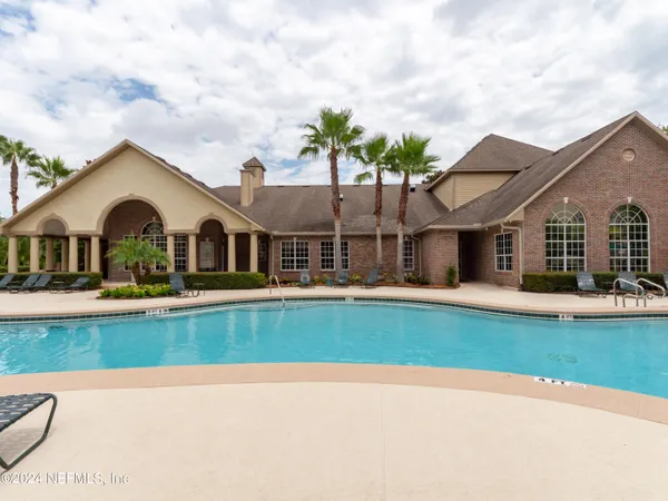 a view of a house with swimming pool and porch with furniture