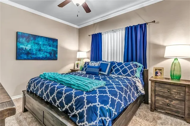 a bedroom with a bed and a lamp on dresser