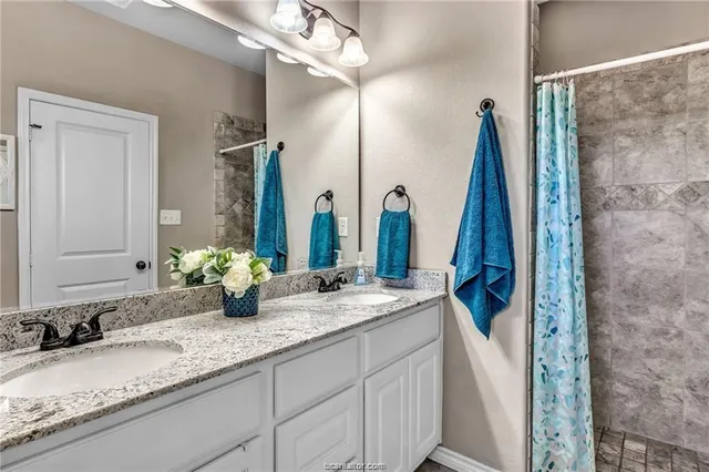 a bathroom with a double vanity sink and a mirror