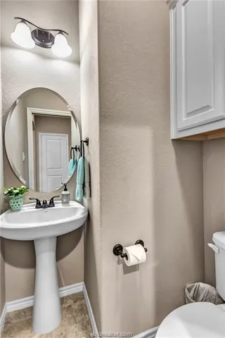 a bathroom with a toilet sink and mirror
