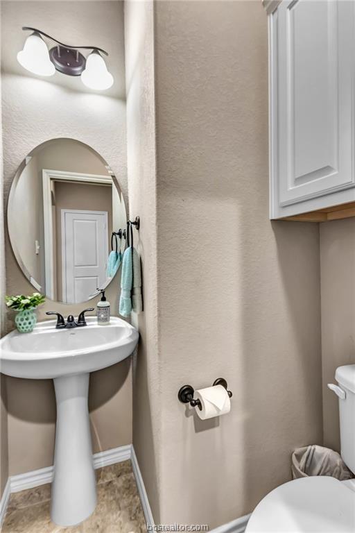 1800 Lonetree Drive College Station, TX 77845 - Photo 19 of 23 a bathroom with a toilet sink and mirror