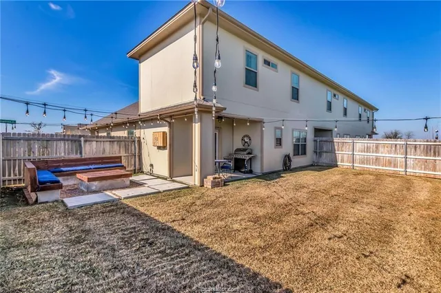 a view of a house with backyard and sitting area