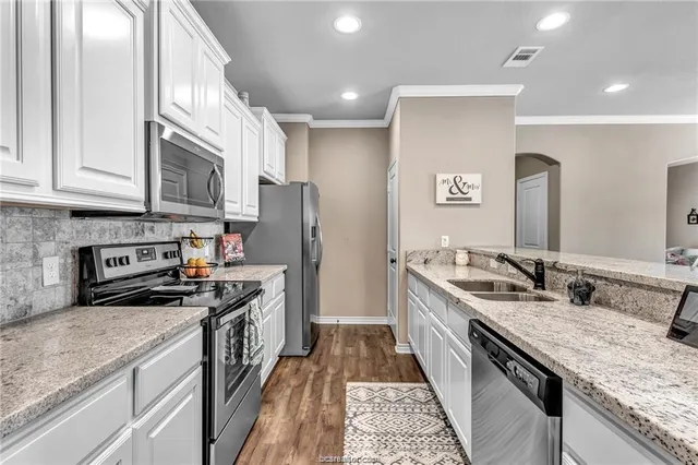 a kitchen with stainless steel appliances granite countertop a sink stove and refrigerator