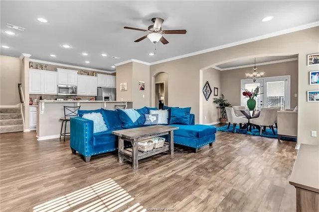 a living room with furniture kitchen view and a chandelier