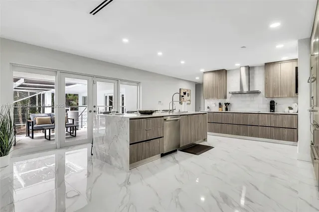 a large white kitchen with lots of counter space and windows