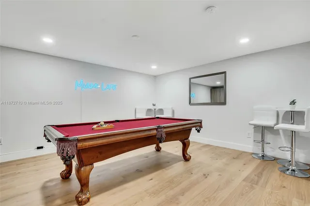 a room with furniture pool table and wooden floor