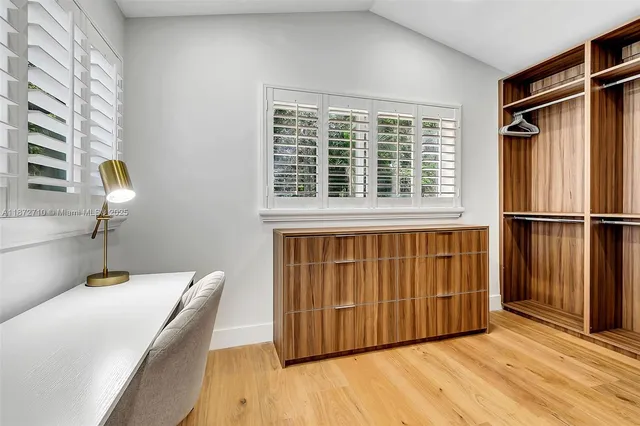a view of a bedroom with wooden floor and a window