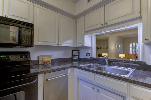 a kitchen with stainless steel appliances granite countertop a sink a stove and cabinets