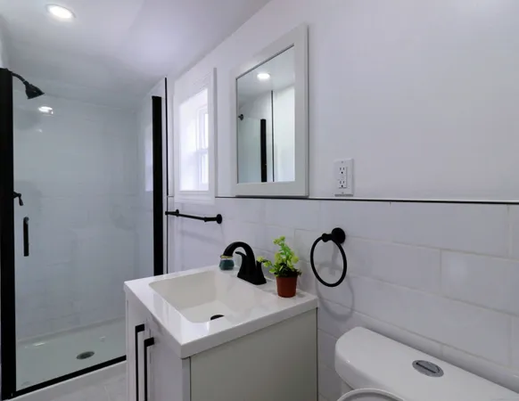 a bathroom with a toilet sink vanity and mirror