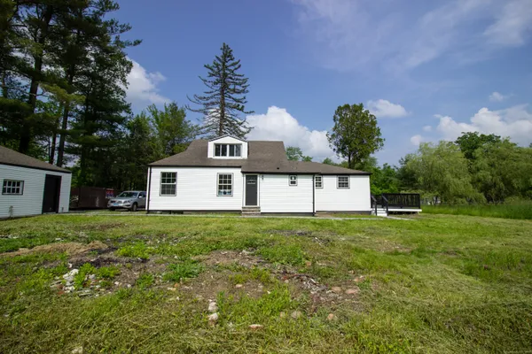 a house with green field in front of it