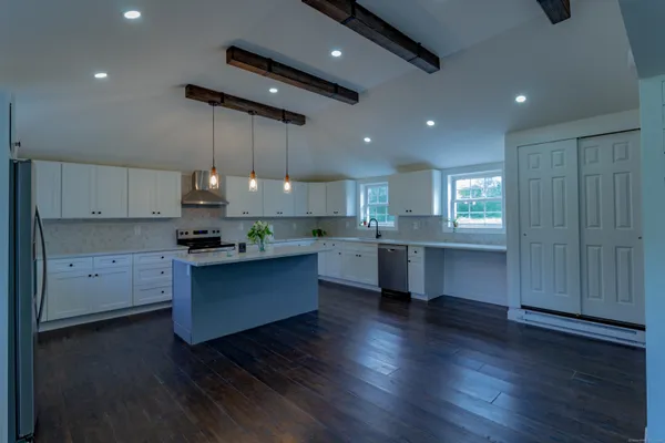a kitchen with stainless steel appliances granite countertop a sink cabinets and wooden floor