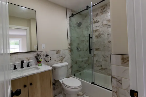 a bathroom with a granite countertop sink toilet and shower