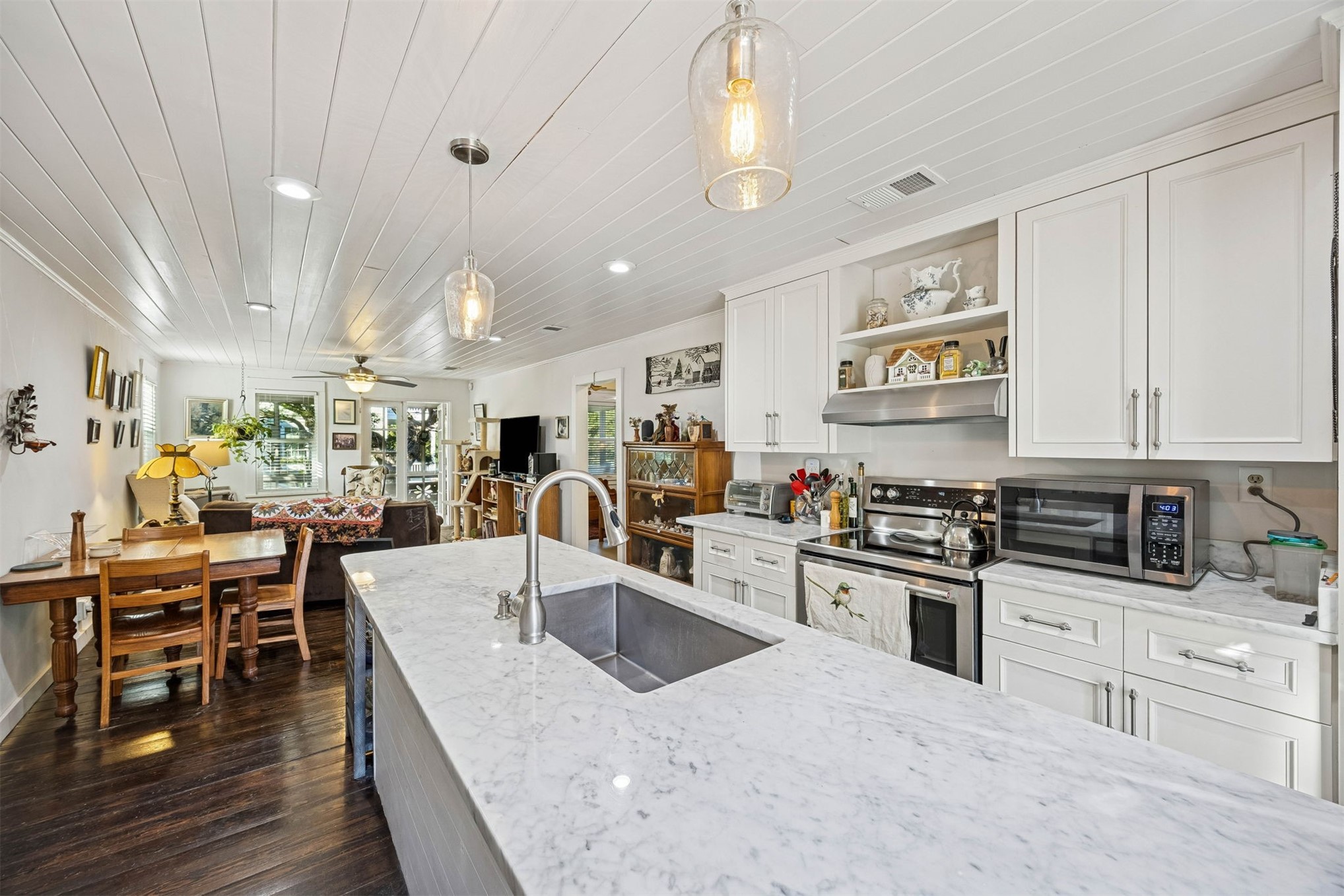 1012 Ladies Street Fernandina Beach, FL 32034 - Photo 22 of 64 a kitchen with stainless steel appliances granite countertop a stove top oven a sink a dining table and chairs with wooden floor