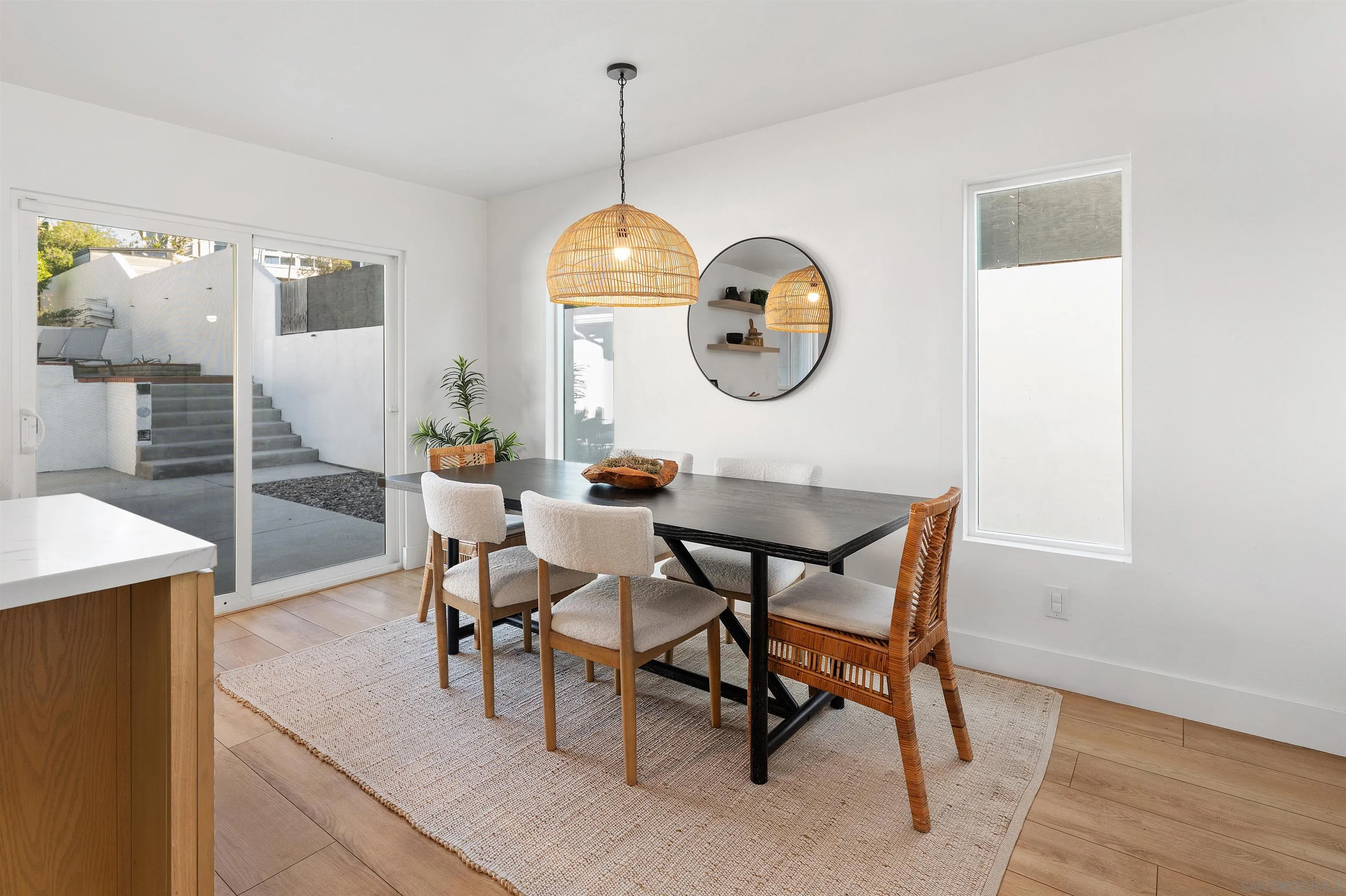 2103 Garfield Road San Diego, CA 92110 - Photo 10 of 34 a dining room with wooden floor a chandelier a wooden table and chairs