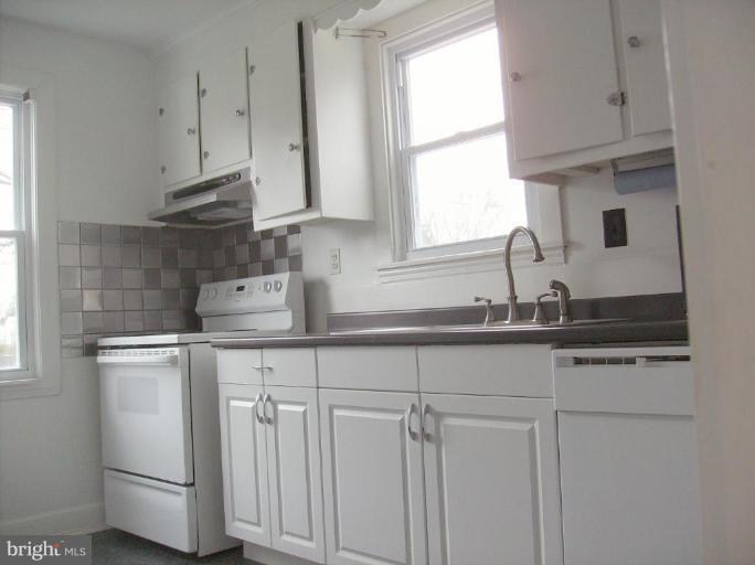 4133 Maple Road Suitland, MD 20746 - Photo 6 of 10 a kitchen with white cabinets and window