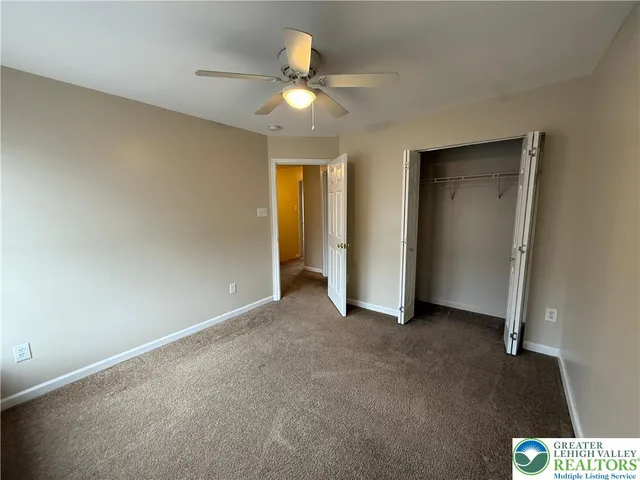 an empty room with closet and chandelier fan