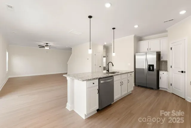 a large kitchen with granite countertop a sink a counter space appliances and cabinets