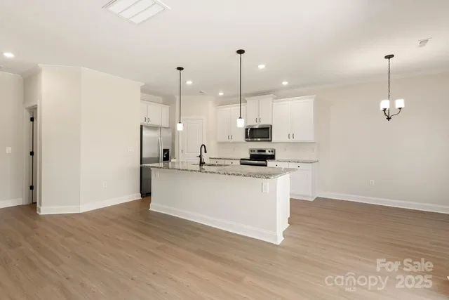 a white kitchen with wooden floor