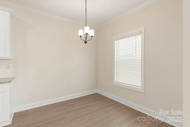 a view of empty room with wooden floor and window