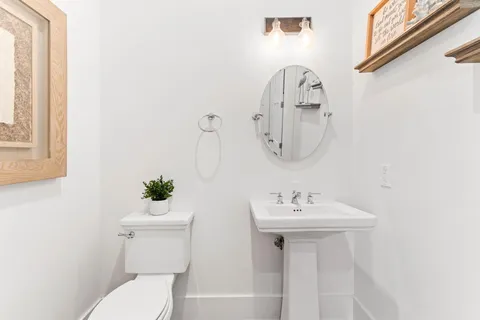 a bathroom with a toilet sink and mirror