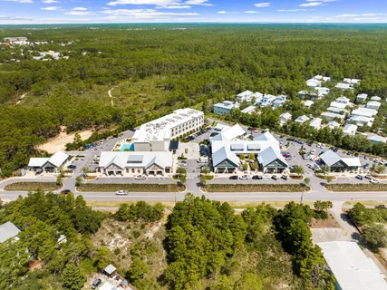 a view of a cafe with a couple of people seating on table and chairs