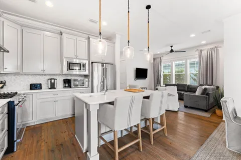 a kitchen with stainless steel appliances kitchen island granite countertop a stove a sink a dining table and chairs