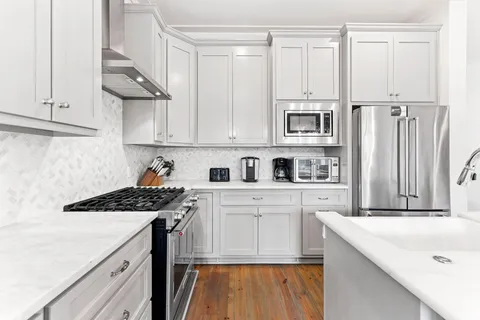 a kitchen with stainless steel appliances granite countertop a stove a sink and a refrigerator