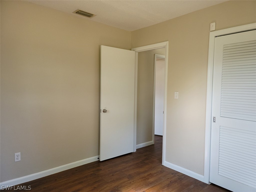 1509 Lindale Circle Lehigh Acres, FL 33936 - Photo 13 of 16 a view of an empty room with wooden floor