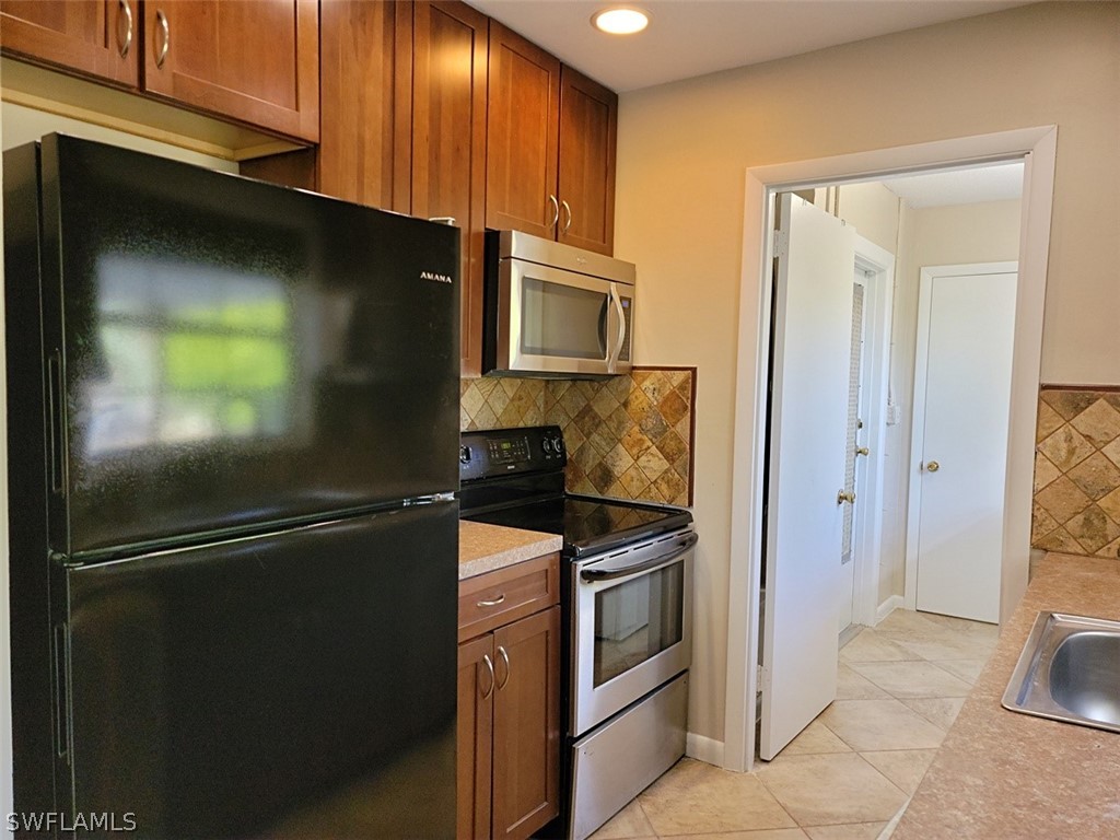 1509 Lindale Circle Lehigh Acres, FL 33936 - Photo 5 of 16 a kitchen with a refrigerator stove and cabinets